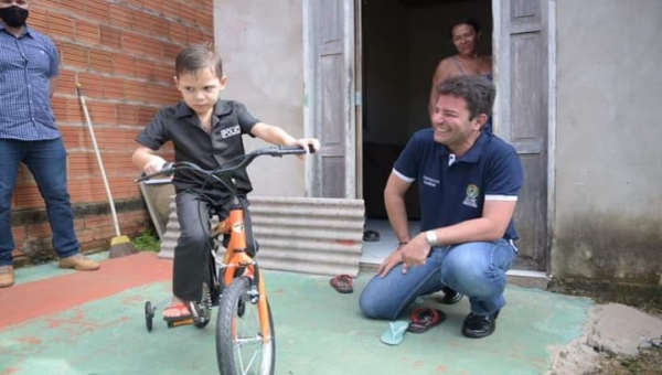 No bairro Placas, Gladson presenteia criança com bicicleta e conversa com moradores